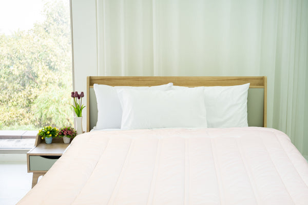 Organic Topper on the bed with green pillows